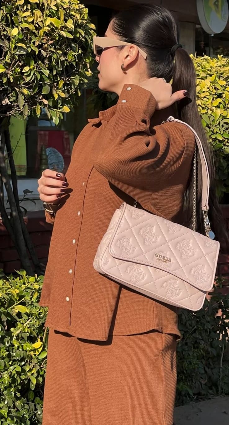 Side view of brown knit co-ord set highlighting the quilted shoulder bag