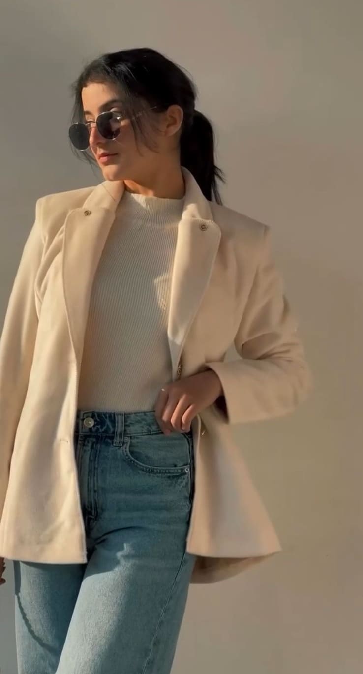 Cream wool-blend blazer over rib-knit with light denim jeans and round sunglasses
