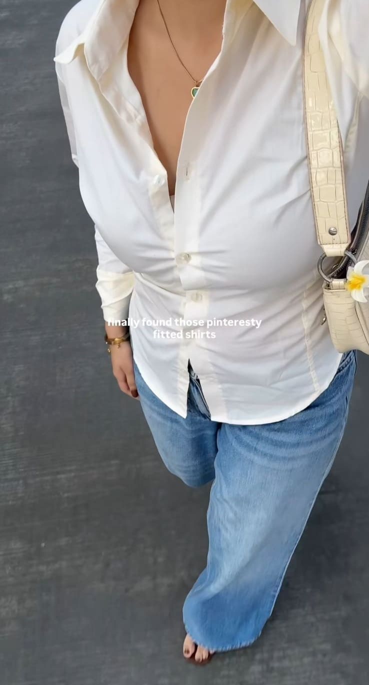 Top-down view of cream fitted button-down shirt with wide-leg light jeans