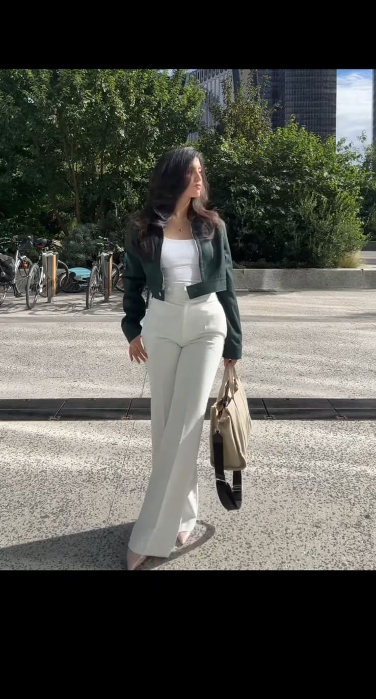 Dark green cropped jacket over white tank with white wide-leg trousers and a beige tote