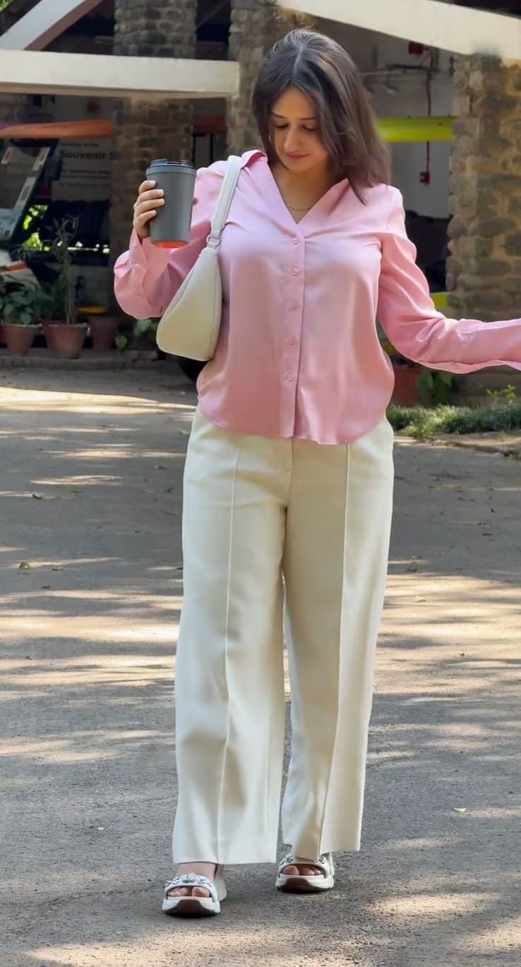 Pink satin shirt with cream wide-leg trousers and cream shoulder bag