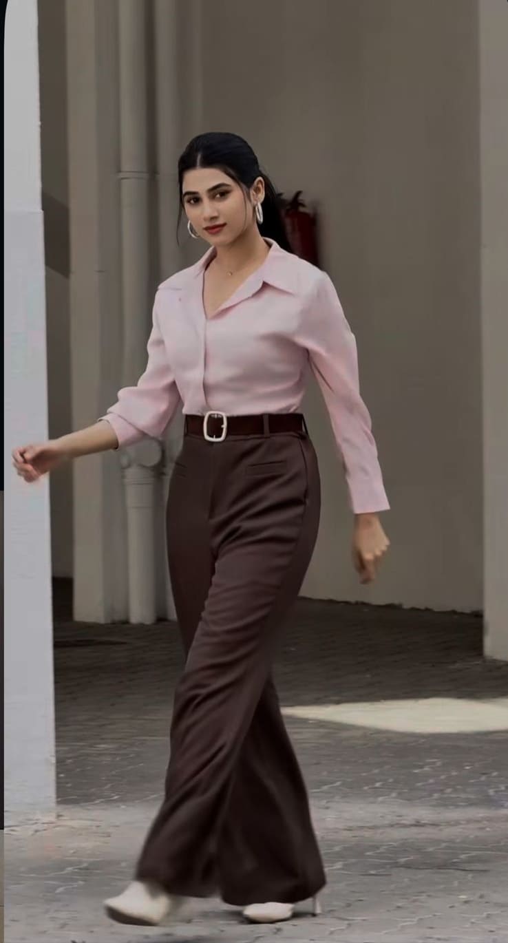 Soft pink shirt tucked into high-waist brown wide-leg trousers with a belt