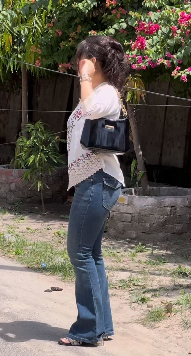 White embroidered boho top with bootcut jeans and a black structured bag